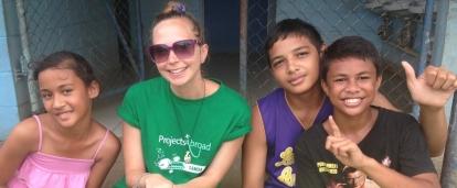 A Projects Abroad volunteer takes a picture with children at a placement in Samoa A volunteers takes a picture with children at her placement in Samoa